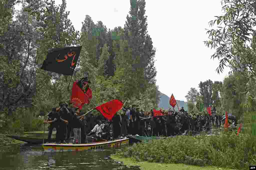 بھارت کے زیر انتظام کشمیر کی ڈل جھیل پر کشتیوں میں بیٹھ کر لوگ جلوس نکال رہے ہیں۔&nbsp;