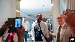 FILE - Sylvain Itte, French Ambassador to Niger, greets French journalist Olivier Dubois, center, at the airport in Niamey, Niger, March 20, 2023. Itte left Niger on Wednesday, about a month after the military government ordered his expulsion.