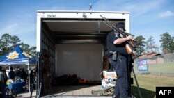 A police officer secures guns to be transported in the back of a truck during a gun buyback program in Houston, Texas, Feb. 18, 2023.