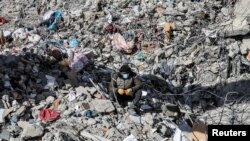 A man sits on the rubble, in the aftermath of a deadly earthquake in Kahramanmaras, Turkey, Feb. 15, 2023. 