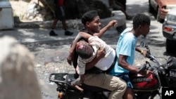 People take a man who was shot in the head during violent gang clashes, to a hospital in the Carrefour-Feuilles district of Port-au-Prince, Haiti, Aug. 15, 2023.