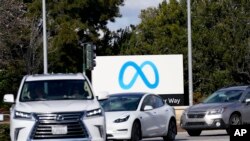 Cars drive past a Meta sign outside of the company's headquarters in Menlo Park, Calif., March 7, 2023.