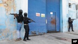 Polis nasyonal Ayiti (PNH) veye Penitansye Nasyonal la ki vid kounyea, apre dife pete andedan enstalasyon an, anbalavil Potoprens, 14 Mas, 2024. 