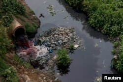 Bangladeş'te tekstil boyası atıkları yüzünden suların kırmızıya boyandığı Buriganga nehri.