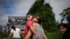 Venezuela migrant Naiber Zerpa holds her son, Mathias Marquez, as they arrive at a temporary camp after walking across the Darien Gap from Colombia, in Lajas Blancas, Panama, June 28, 2024.