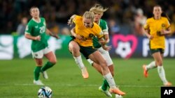 Jwez Ostralyen Ellie Carpenter (a goch) goumen pou pran balon an nan men Irlandez Katie Mc Cabe nan match ouveti Mondyal Foutbol Feminin FIFA a, nan Sydney, Ostrali, 20 Jiye, 2023. 