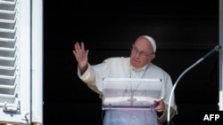 Pope Francis waves from the window of the Apostolic Palace during the weekly Angelus prayer on Oct. 2, 2022 in the Vatican.