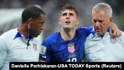 Vedet foutbol Ameriken Christian Pulisic (10) ak responsab seleksyon Etazini apre li blese nan yon kolizyon ak gadyen Iran an, Alireza Beiranvand nan match Gwoup B yo a, 29 Nov. 2022. 