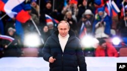 Prezidan Ris la Vladimir Putin pwononse yon diskou pandan yon konse pou make 8em anivese referandom sou eta Krime ak Sevastopol ak reyinifikasyon yo ak La Risi, nan Moskou, Vandredi 18 Mas, 2022.