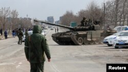 Solda pwo La Risi chita nan yon tank pandan yon konfli an Ikren ak La Risi andeyo vil potye Mariupol, nan sid Ikren, 20 Mas 2022. 