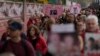 FILE: Family members of those who died of COVID walk past the National Covid Memorial wall in London, Tuesday, March 29, 2022. 