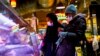 FILE - Customers wear face masks to protect against the spread of the coronavirus as they shop at the Reading Terminal Market in Philadelphia, Feb. 16, 2022. 