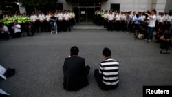 Thành viên gia đình của các nạn nhân trong thảm họa chìm phà Sewol ngồi trước nơi các thành viên phi hành đoàn bị giam giữ.