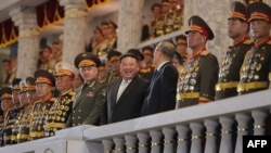 This picture taken on July 27, 2023 and released from North Korea's official Korean Central News Agency (KCNA) on July 28, 2023 shows North Korea's leader Kim Jong Un (C) attending a military parade to mark a key anniversary of the Korean War, with Russia