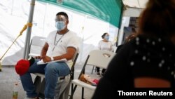 Asylum seekers, under the Migrant Protection Protocols (MPP) program, wait at the Leona Vicario temporary migrant shelter, before being transferred to continue their asylum request in the United States, in Ciudad Juarez