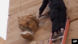 A militant hammers at a sculpted face in the ancient Iraqi city of Hatra in this scene from an Islamic State militant video posted on YouTube, April 3, 2015. The fortified city is recognized as a UNESCO World Heritage site. 