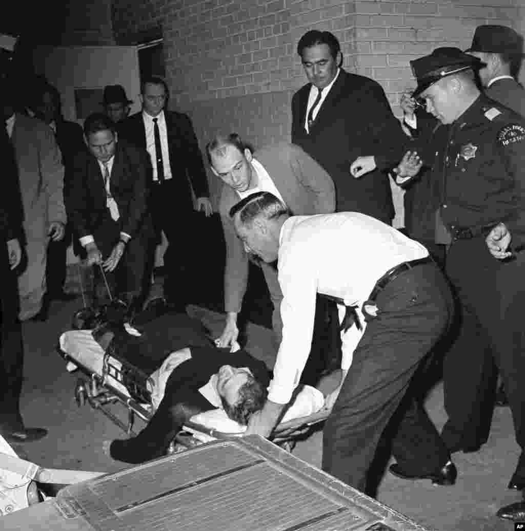 Lee Harvey Oswald, bị cáo buộc ám sát Tổng thống John F. Kennedy, nằm trên cáng sau khi bị bắn vào bụng tại Dallas, Texas, ngày 24/11/1963