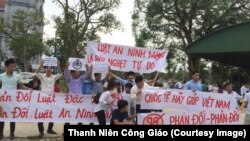 Người biểu tình giơ cao biểu ngữ tại Giáo hạt Văn Hạnh ở Hà Tĩnh.