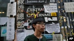 Sinh viên Joshua Wong 17 tuổi lãnh đạo phong trào xuống đường ở Hong Kong đứng trược trụ sở chính phủ sau một cuộc họp báo trong khu vực biểu tình ở trung tâm Hong Kong, 9/10/14