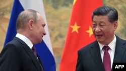 Russian President Vladimir Putin (L) and Chinese President Xi Jinping pose for a photograph during their meeting in Beijing, on February 4, 2022.