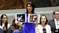 U.S. Ambassador to the United Nations Nikki Haley shows pictures of Syrian victims of chemical attacks as she addresses a meeting of the Security Council on Syria at U.N. headquarters, in New York, April 5, 2017. 