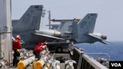 Thủy thủ tàu USS Carl Vinson chuẩn bị gắn rốc kết cho máy bay F-18 trước cuộc tuần tra thường lệ tại Biển Đông ngày 3/3/2017. 