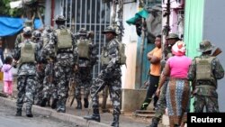 FILE PHOTO: A member of the Mozambique military, looks on as they patrol the streets of the capital a day after a "national shutdown" against the election outcome, in Maputo