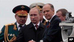 Ảnh tư liệu - Tổng thống Nga Vladimir Putin (giữa) và Bộ trưởng Quốc phòng Sergei Shoigu (trái), Trưởng ban An ninh Liên bang Alexander Bortnikov (phải) sau khi duyệt đội tàu chiến trong buổi diễu hành hải quân đánh dấu Ngày Chiến thắng ở Sevastopol, Crimea, ngày 9 tháng 5 năm 2014.