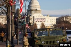 ABD Ulusal Muhafızları Washington'da, ABD Başkanı seçilen Donald Trump'ın başkanlık yemin töreni öncesinde, arka planda Capitol Hill'in bulunduğu Pennsylvania Caddesi'nde devriye geziyor- 18 Ocak 2025.