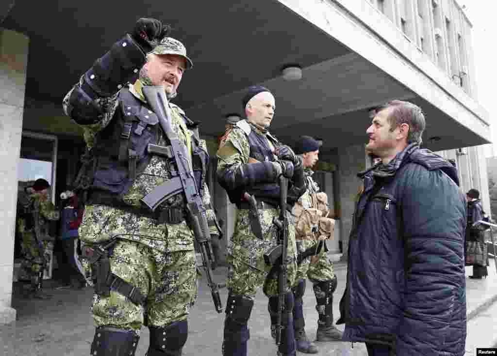 Cư dân nói nói chuyện với dân quân vũ trang thân Nga canh gác bên ngoài văn phòng thị trưởng&nbsp;ở Slaviansk, Ukraine, ngày 14/4/2014.