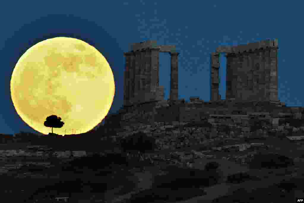 Siêu mặt trăng (supermoon) đang lên cạnh ngôi đền cổ Poseidon, ở Mũi Sounion ở hướng nam Athens, Hy Lạp, 23/6/13 