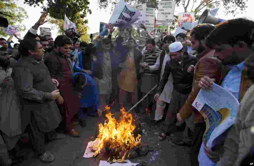 احتجاج کے دوران مشتعل مظاہرین امریکی صدر ڈونلڈ ٹرمپ کا پتلا نظر آتش کرتے ہوئے