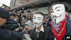 Dân Hong Kong thân dân chủ, đeo mặt nạ của nhóm Anonymous, xô xát với cảnh sát trong một cuộc biểu tình phản đối chính phủ Trung Quốc can thiệp vào cuộc bầu cử ở Hong Kong 