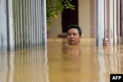 Vietnam'ın Thai Nguyen kentinde bir adam evinin dışında suların içinden yürümeye çalışıyor.