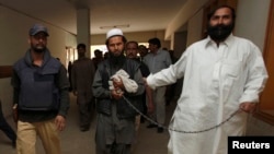 Cảnh sát Pakistan áp tải chỉ huy quân sự hàng đầu của phe Taliban Mullah Abdul Ghani Baradar.