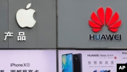 Biểu tượng của Apple và Huawei được trưng bày bên ngoài cửa hàng bán diện thoại di động tại Thâm quyến tỉnh Quảng Đông (ảnh chụp ngày 7/3/2019)