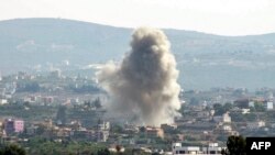 This picture taken from Lebanon's southern city of Tyre shows a cloud of smoke erupting following an Israeli air strike on the village of Sammaiyah on October 14, 2024.