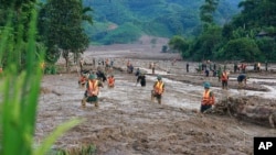 Các nhân viên cứu hộ tìm người mất tích sau một trận lũ quét ở Lào Cai.