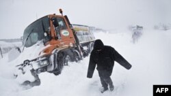 Dân chúng đi bộ trên con đường phủ tuyết trắng xóa ở ngoại ô thủ đô Bucharest, Romania hôm 26/1/12