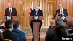 Thủ tướng Anh Boris Johnson (giữa) trong cuộc họp báo về virus corona tại London vào ngày 3/3/2020. 