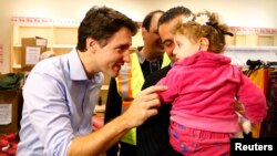 Thủ tướng Canada Justin Trudeau (trái) chào đón người tị nạn Syria đến phi trường Toronto ngày 11/12/2015. 