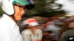 Nhà lãnh đạo đối lập Campuchia Sam Rainsy đội mũ bảo hiểm đến tham gia cuộc biểu tình ở Phnom Penh, 16/12/13 đòi chính phủ tổ chức bầu cử lại