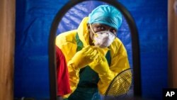 Nhân viên y tế mặc quần áo bảo hộ trước khi vào trung tâm điều trị Ebola ở phía tây của Freetown, Sierra Leone.