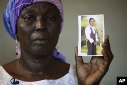 Bà Martha Mark ở Chibok, Nigeria, mẹ của em gái Monica Mark bị bắt cóc, khóc trong khi cho phóng viên xem ảnh con gái mình.