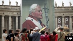 Tín đồ Công giáo bên cạnh tấm ảnh của Đức cố Giáo Hoàng John Paul II tại Quảng trường Thánh Phê-rô