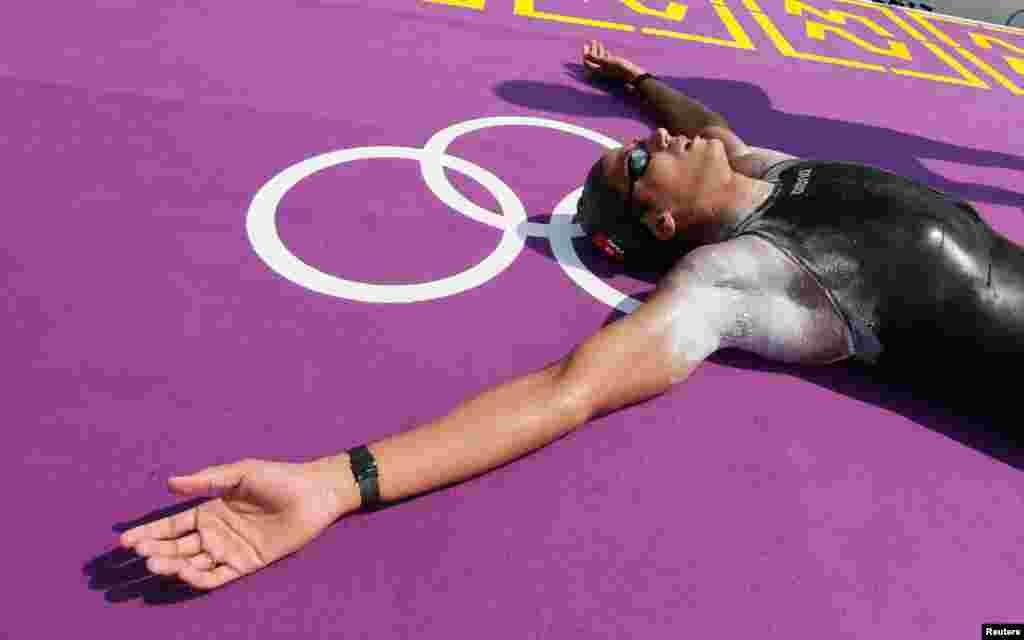 Oussama Mellouli của Tunisia nằm lăn ra s&acirc;n sau khi gi&agrave;nh huy chương v&agrave;ng m&ocirc;n bơi marathon 10 km nam. REUTERS/Stefan Wermuth