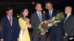 Tổng thống Obama nhận hoa khi bước xuống máy bay tại sân bay Nội Bài ở Hà Nội, tối ngày 22/5/2016.