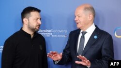 (FILES) German Chancellor Olaf Scholz (R) greets Ukrainian President Volodymyr Zelensky as he arrives to attend the Ukraine Recovery Conference in Berlin on June 11, 2024.