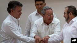 Chủ tịch Cuba Raul Castro (giữa) khuyến khích Tổng thống Colombia Juan Manuel Santos (trái) và thủ lãnh FARC Timoleon Jimenez bắt tay sau khi trở ngại cuối cùng để đạt một thỏa thuận hòa bình đã được khắc phục tại cuộc hội đàm ở Havana, ngày 23/9/2015.