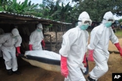 Toán chôn cất khiêng thi thể của một phụ nữ bị nghi đã chết vì Ebola ở Monrovia, Liberia.